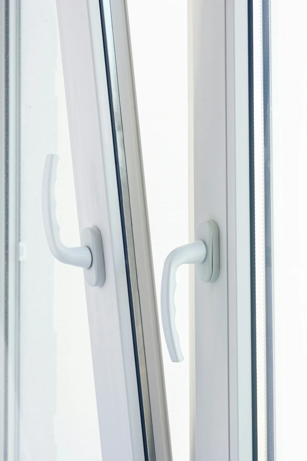 Close view of white window handles, glazing edges and black rubber seals.